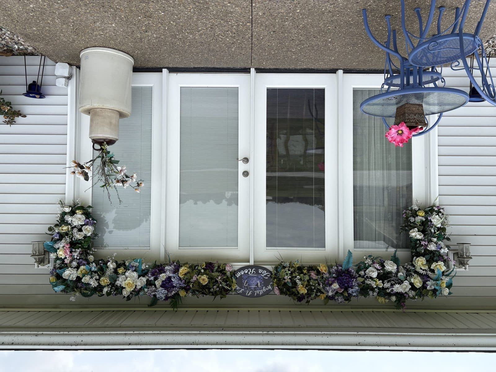 The entrance under its floral swag, with the oval sign above the door