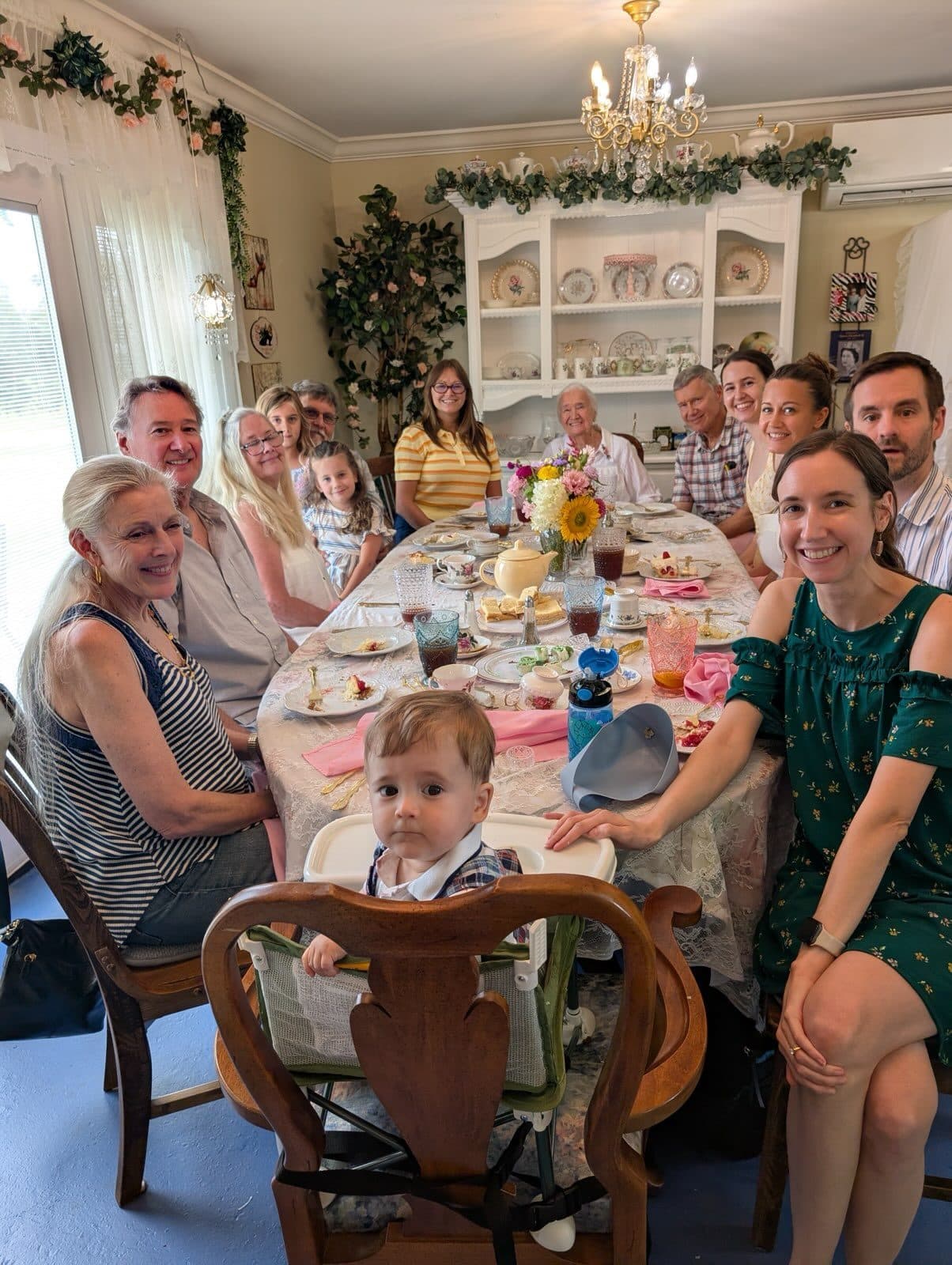 A party of guests seated around the long table for afternoon tea