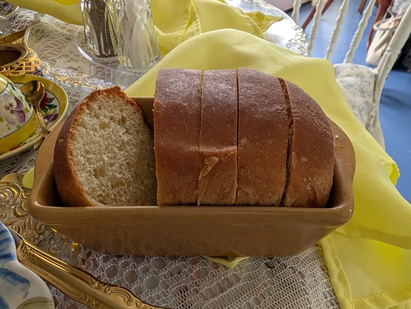 A sliced loaf of homemade bread in a wooden trencher