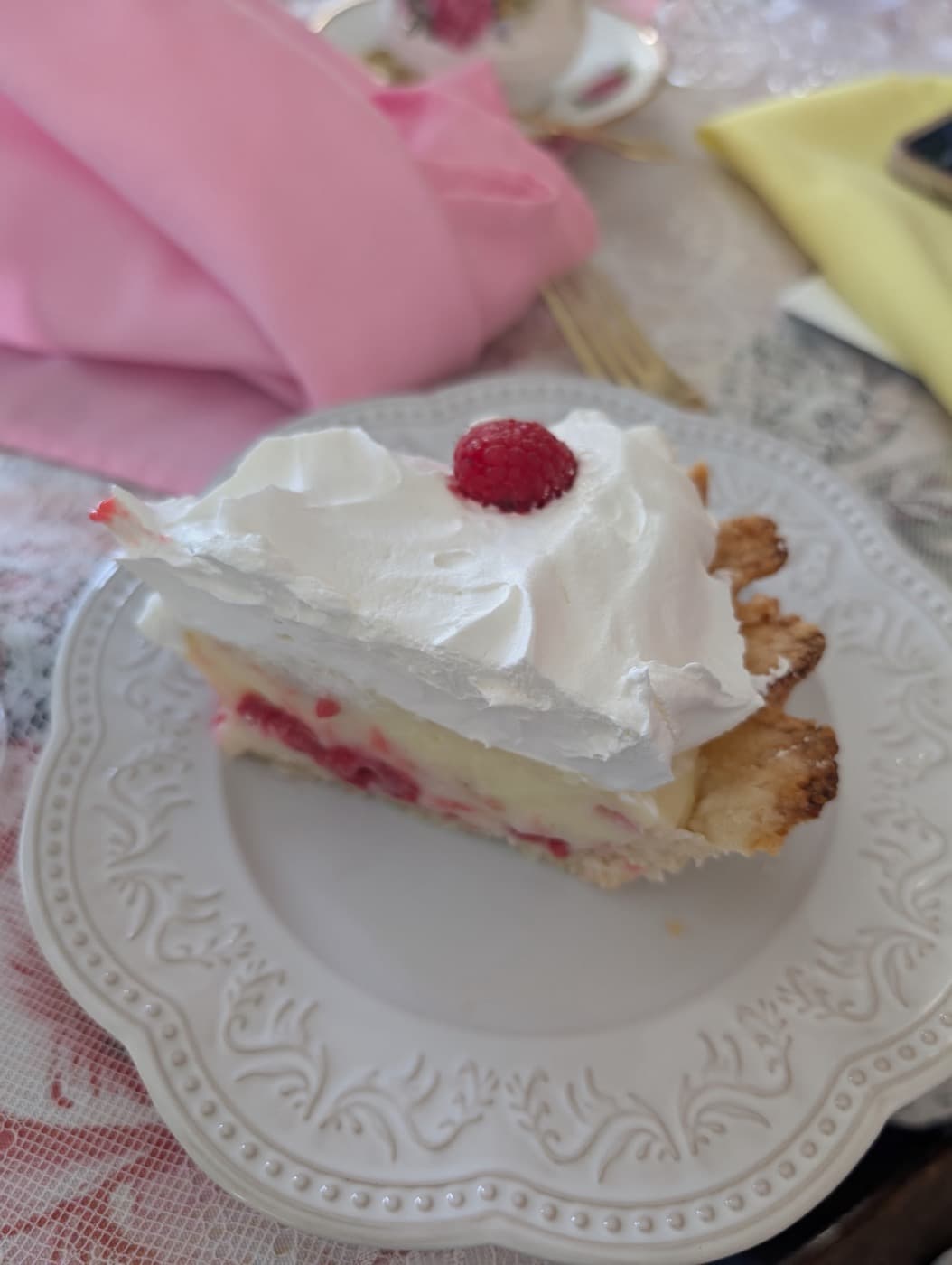 A slice of raspberry cream pie on a scalloped plate