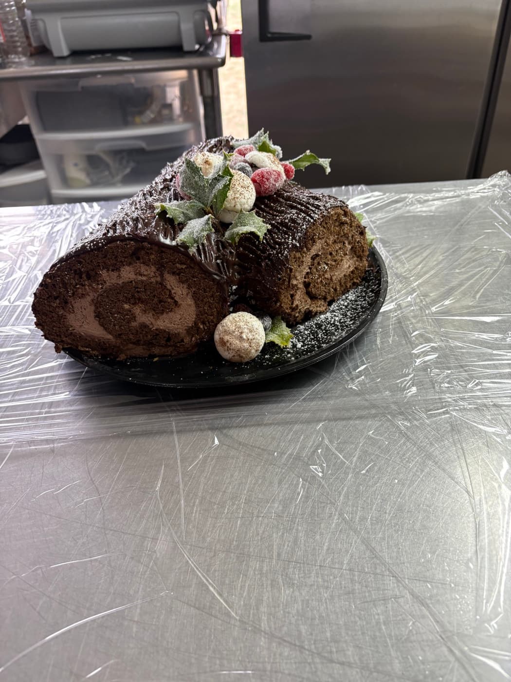 A chocolate yule log with sugared berries and holly