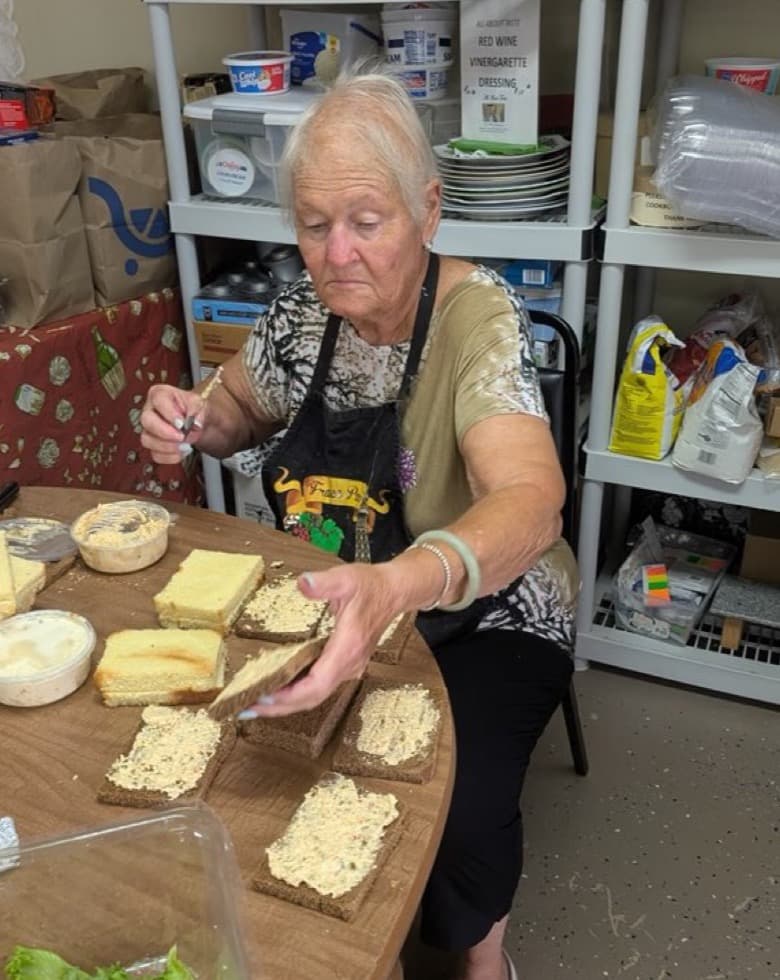 Ginny in her apron, building the tea sandwiches by hand